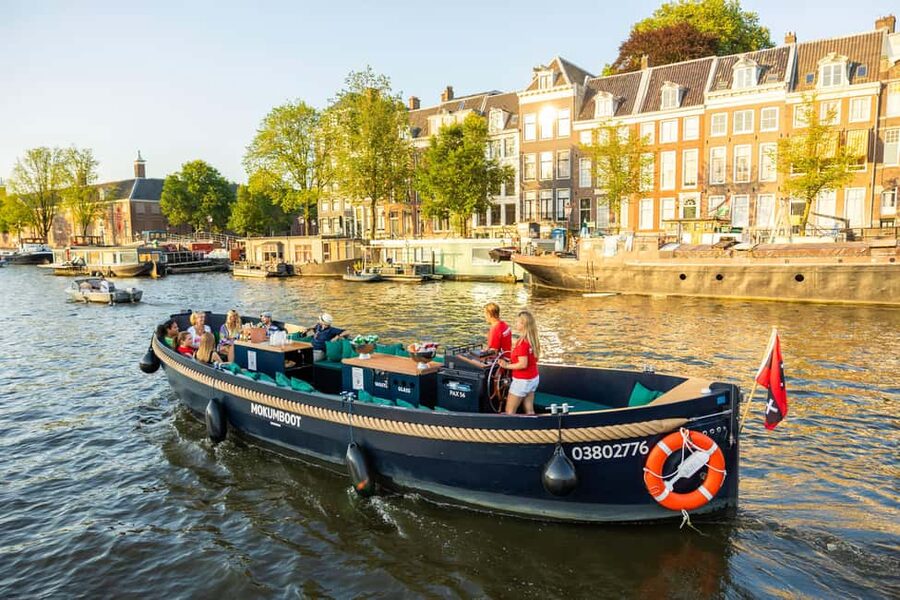 Amsterdam: Guided Open Boat Canal Cruise Including Drink - Guide commentary and the onboard mood